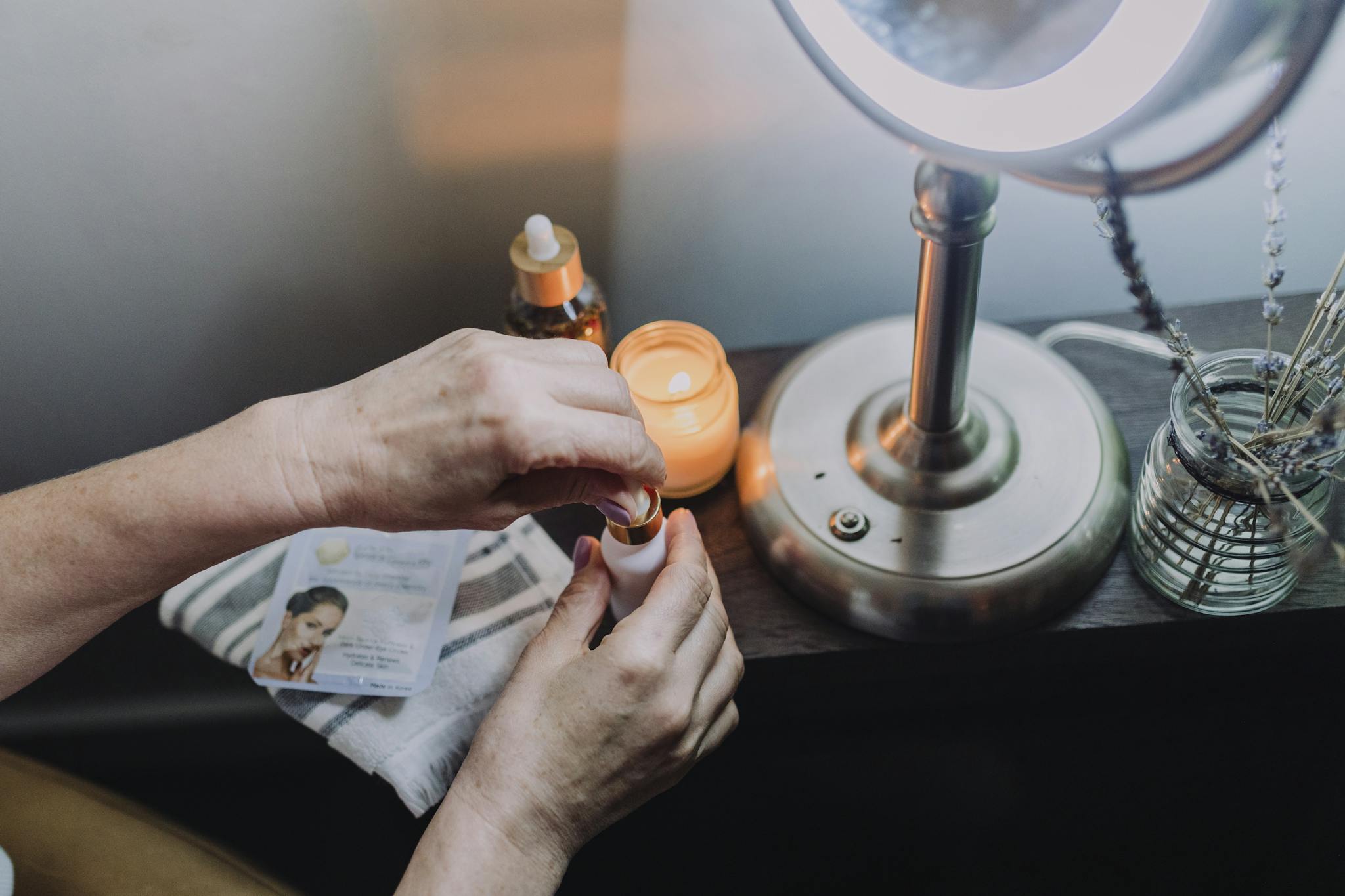 About 3 A serene skincare ritual by candlelight featuring hands applying essential oils, promoting relaxation and self-care.